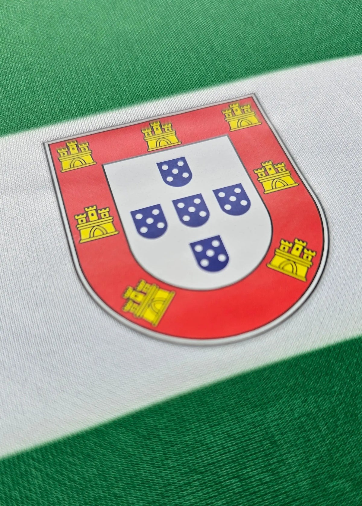 Close-up of the red and gold Portugal federation shield crest with five blue shields, Flavio Gonçalves' Sporting CP shirt.