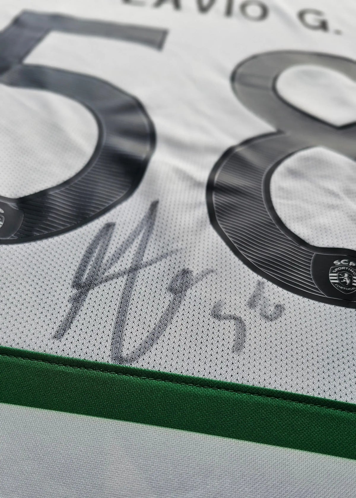Close-up of the number 58 and a grey-marker signature on white fabric, from Flavio Gonçalves' signed Sporting CP shirt.