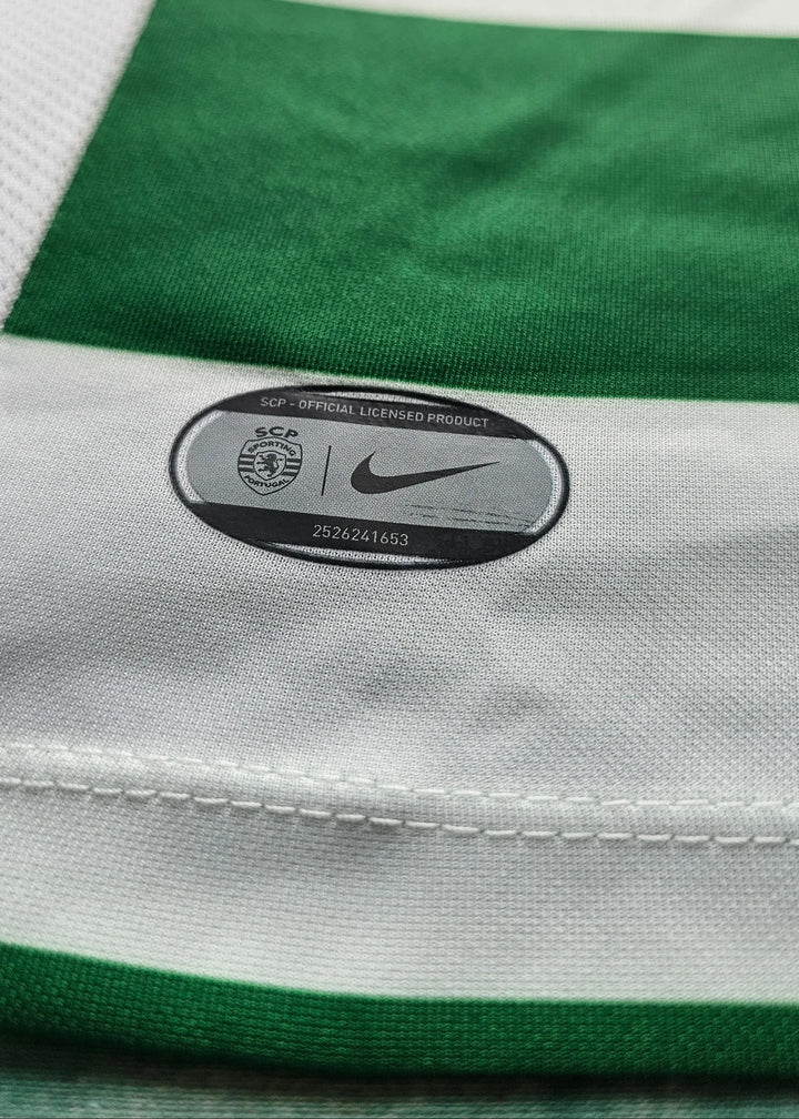Close-up of a Nike and SCP official licensed product tag sewn into green and white striped fabric, Flavio Gonçalves' Sporting CP shirt.