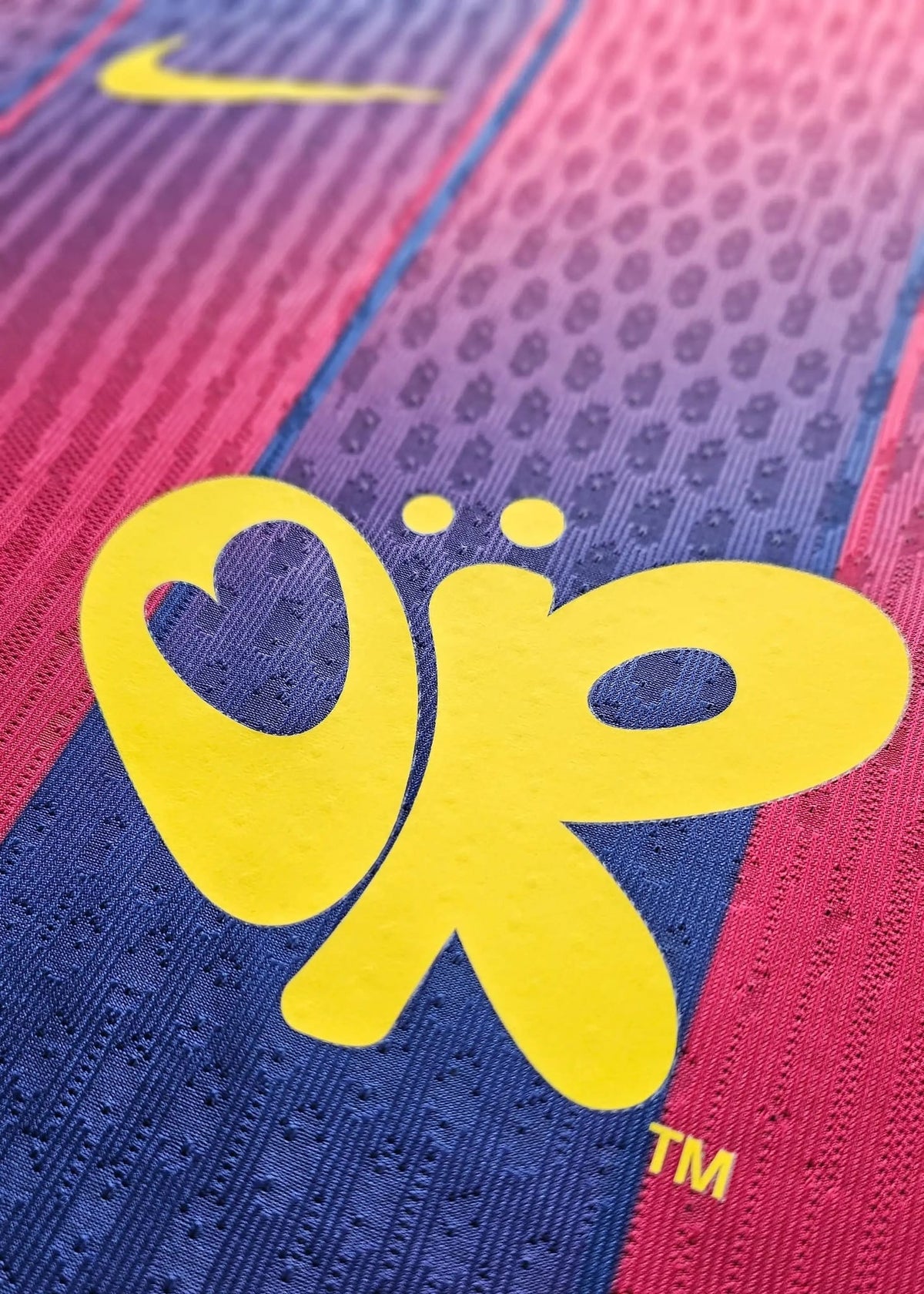 Yellow butterfly-shaped Olivia Rodrigo logo with a TM mark, printed near a yellow Nike swoosh on Frenkie de Jong's Barcelona shirt, No. 21.