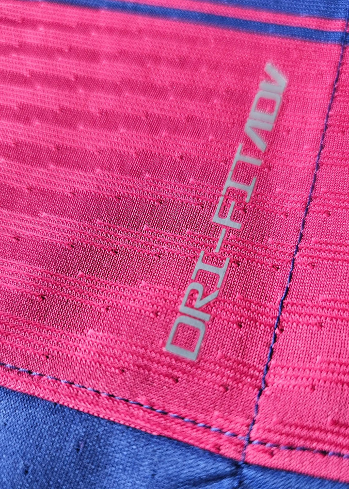 Grey Nike Dri-FIT ADV wordmark on a pink panel, stitched at the seam above a blue section, on Frenkie de Jong's FC Barcelona 2025-2026 shirt.