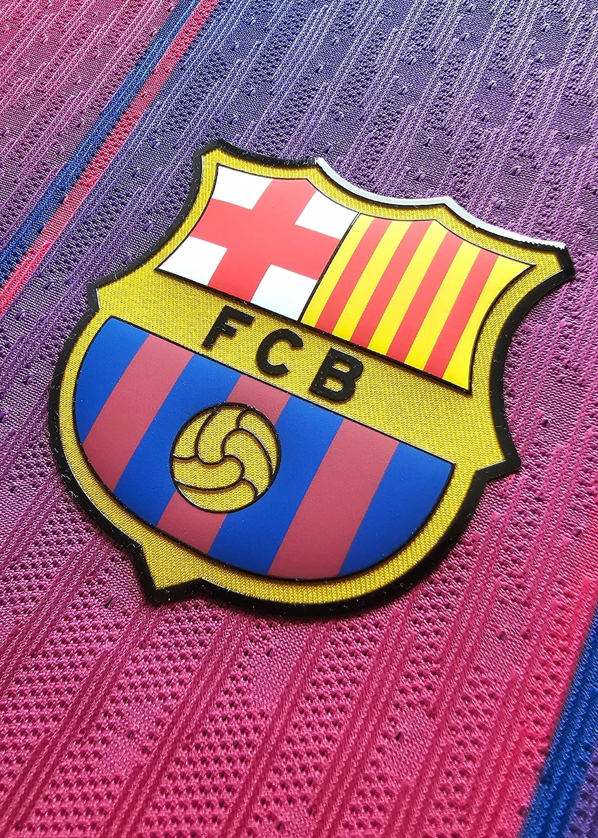 FC Barcelona's red-and-blue striped crest with the Catalan cross and 'FCB' lettering, on Frenkie de Jong's 2025-2026 shirt, No. 21.