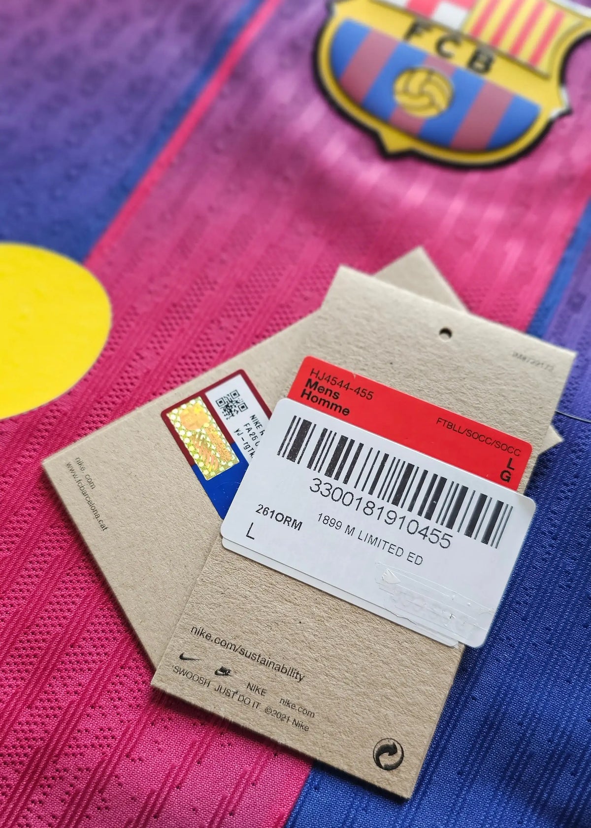 Nike swing tags and the FC Barcelona crest on the folded shirt beneath them, part of Frenkie de Jong's Limited Edition packaging.