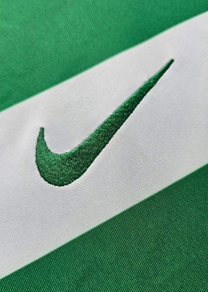 Embroidered Nike swoosh stitched into the green and white hooped fabric of Geovany Quenda's Sporting CP shirt.
