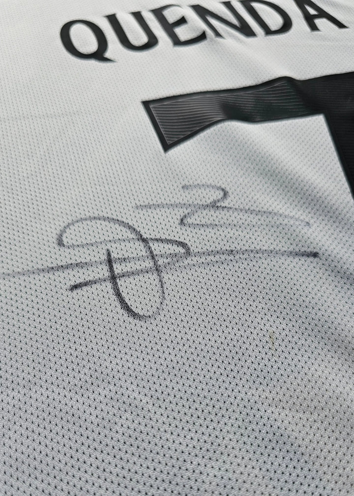 Close-up of the black signature beneath the Quenda nameset on the white Sporting CP shirt.