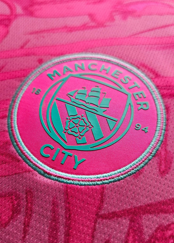 Back view displaying the Manchester City crest in teal on a pink background with the year 1894.
