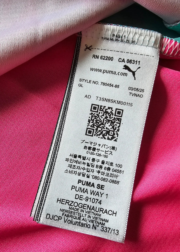 Close-up of a Puma care label on a pink Manchester City shirt, showing a QR code and the Puma SE address in Herzogenaurach.
