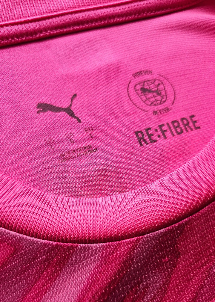 Interior neck view of a pink Manchester City shirt showing a Puma logo, a 'RE:FIBRE Forever Better' stamp, and a Made in Vietnam mark.