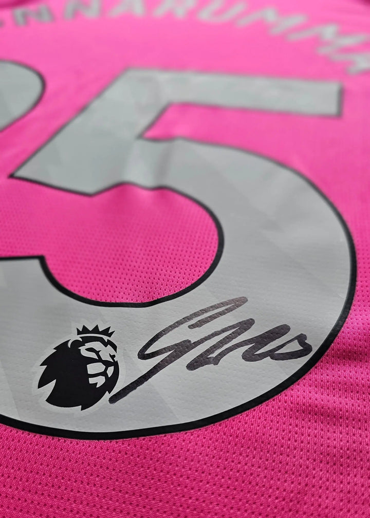 Close-up of the No. 25 on a pink Manchester City shirt, with Gianluigi Donnarumma's signature beside a Premier League lion crest.
