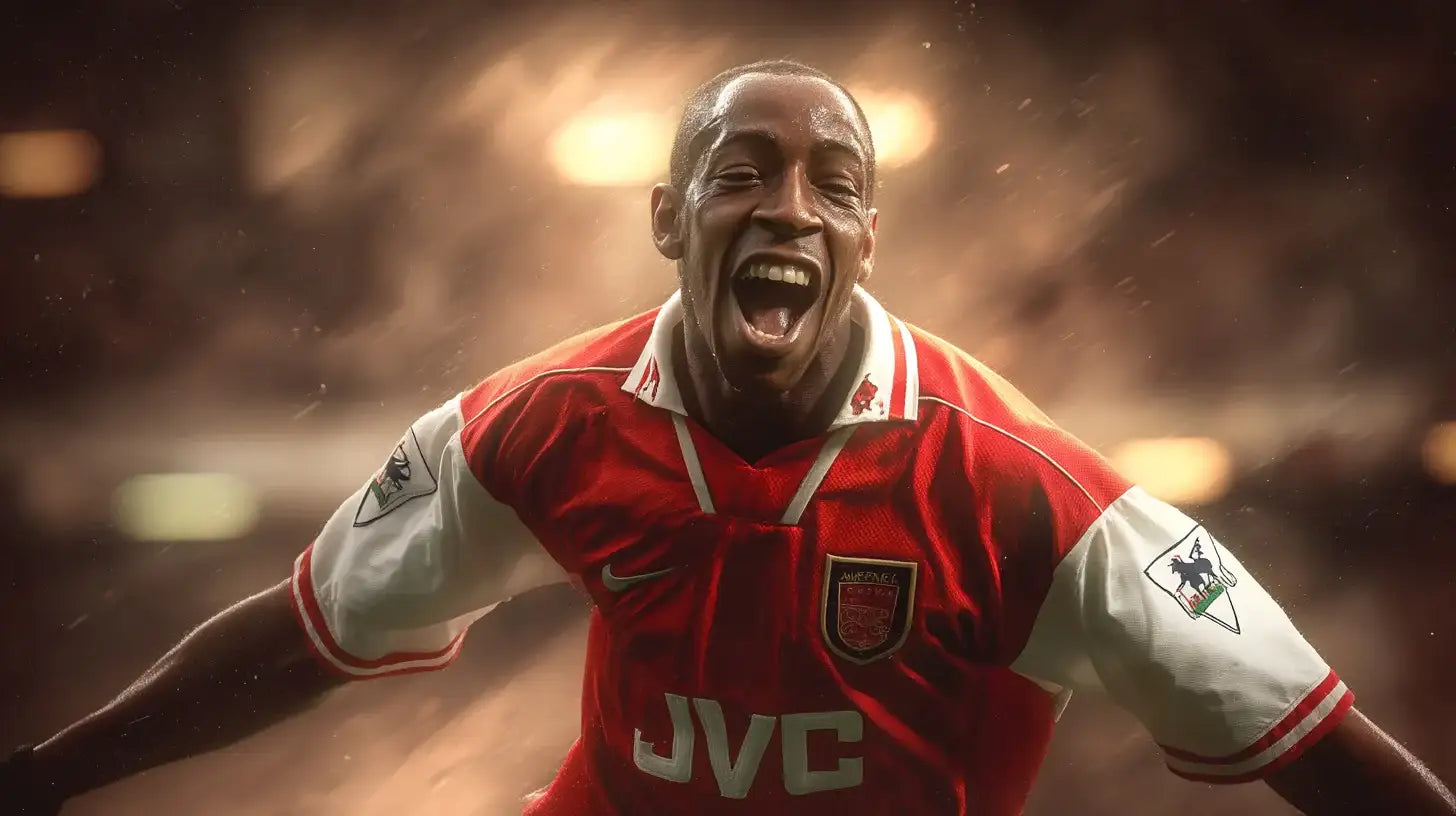 Ian Wright of Arsenal celebrates with arms wide and mouth open while wearing the red home football shirt with white sleeves and JVC sponsor.