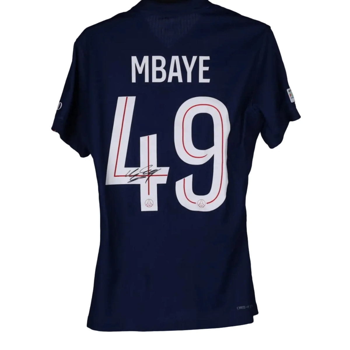A navy blue Paris Saint-Germain football jersey shown from the back, featuring 'MBAYE' and the number '49' in white with red outlines. The jersey is signed in black ink and hangs on a black hanger branded 'MWS' against a solid gray background.
