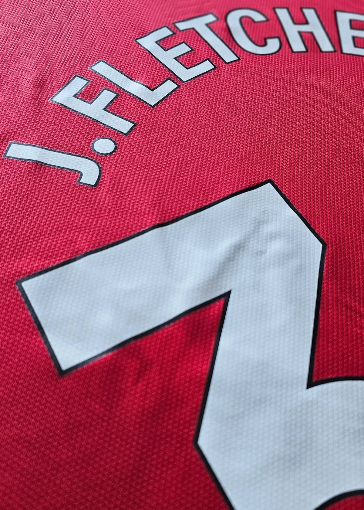 Close-up view highlighting J. Fletcher and No. 38 on a red football shirt.