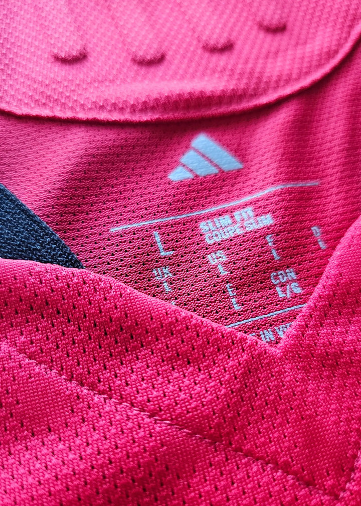 Size label showing L with UK, US, and CON sizes on a pink football shirt.