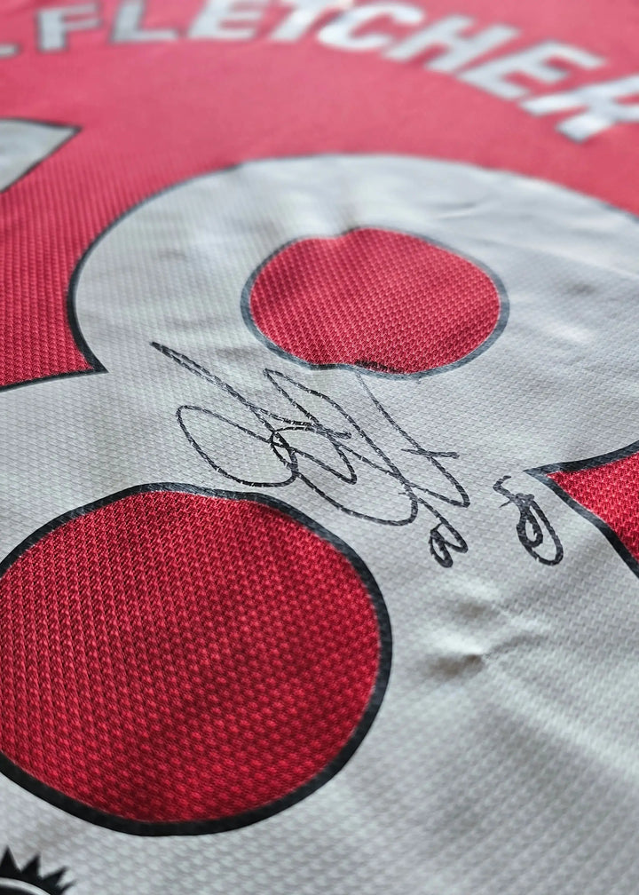 Close-up view of No. 38 with signature of Jack Fletcher on a red football shirt.