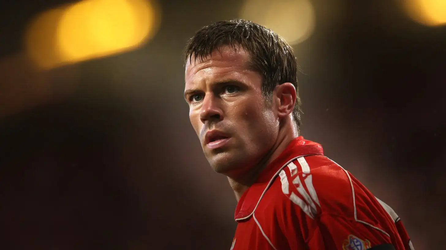 Jamie Carragher in a red Liverpool shirt, intense close-up as he looks to the side with stadium lights in the distance.
