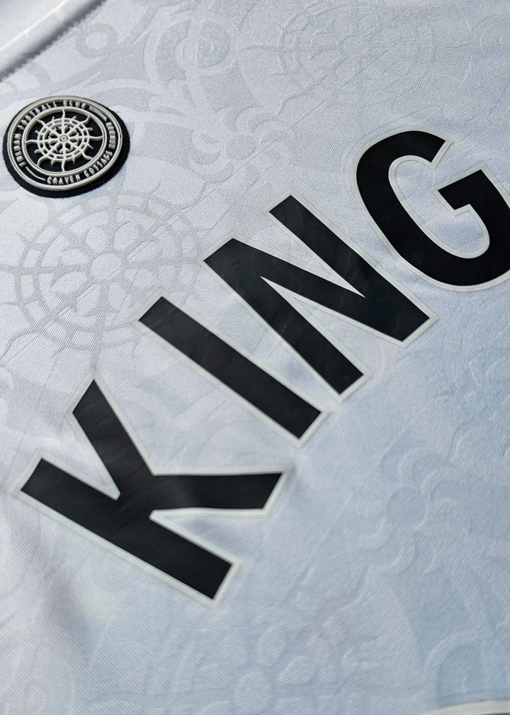 Close-up of the black KING nameset lettering beside the Fulham FC Craven Cottage crest patch, Josh King's Fulham F.C. 2025-2026 shirt.