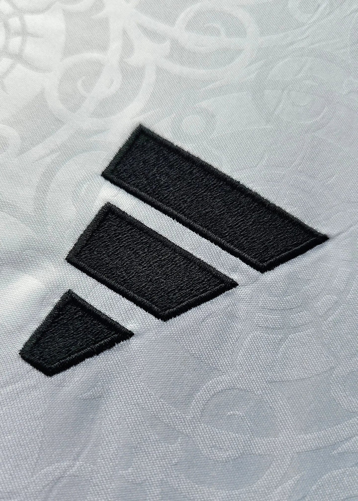 Close-up of the black Adidas three-stripe logo on the sleeve of white fabric, Josh King's Fulham F.C. 2025-2026 shirt.