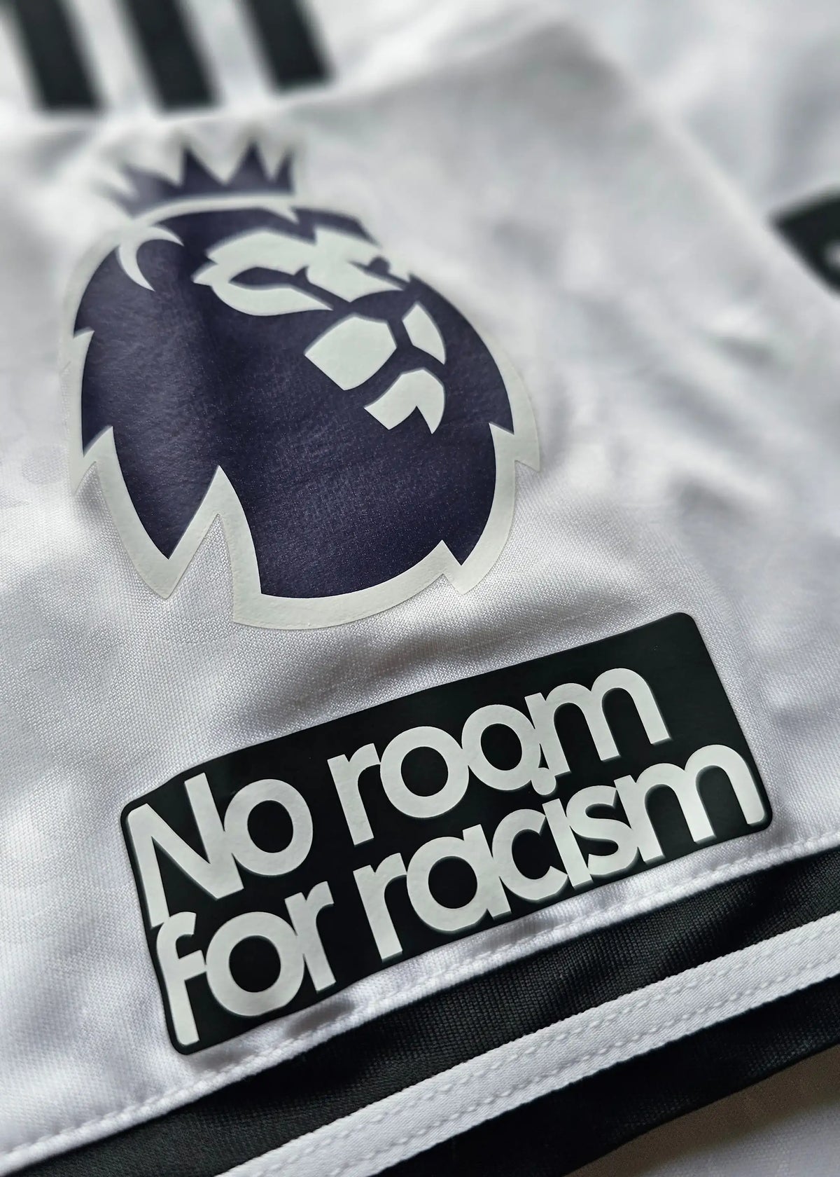 Close-up of the Premier League lion crest and a No Room For Racism patch on the sleeve, Josh King's Fulham F.C. 2025-2026 shirt.