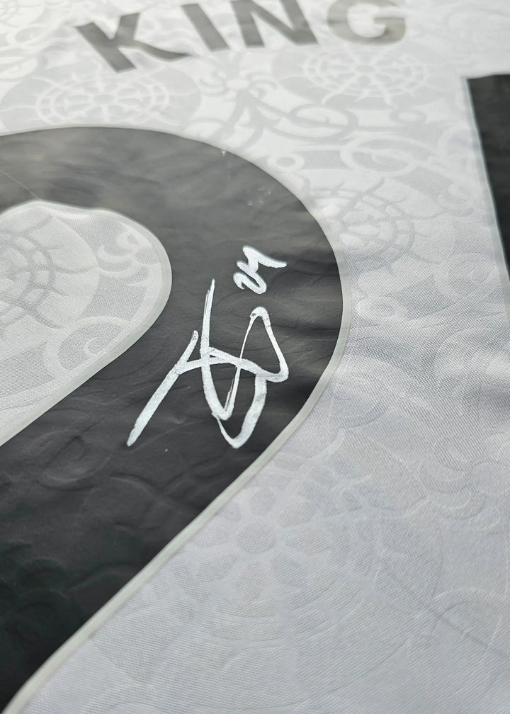 Close-up of a silver-marker signature over white tonal jacquard fabric, from Josh King's signed Fulham F.C. 2025-2026 No. 24 shirt.