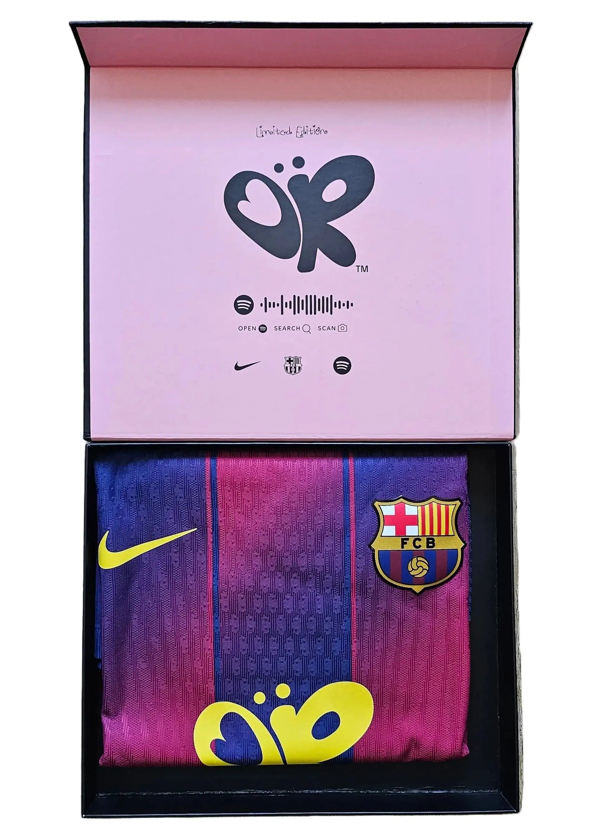 An open presentation box displaying a folded FC Barcelona soccer jersey. The top of the box is pink with a black logo, and the bottom tray holds the jersey, which features a blue-to-pink gradient, yellow Nike swoosh, and FC Barcelona crest.