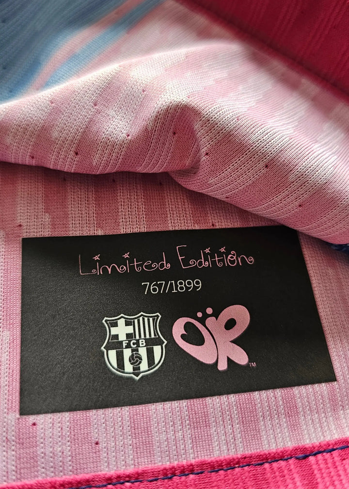 Close-up of pink striped fabric with a black label reading Limited Ediciones 7671899 beside the FC Barcelona crest.