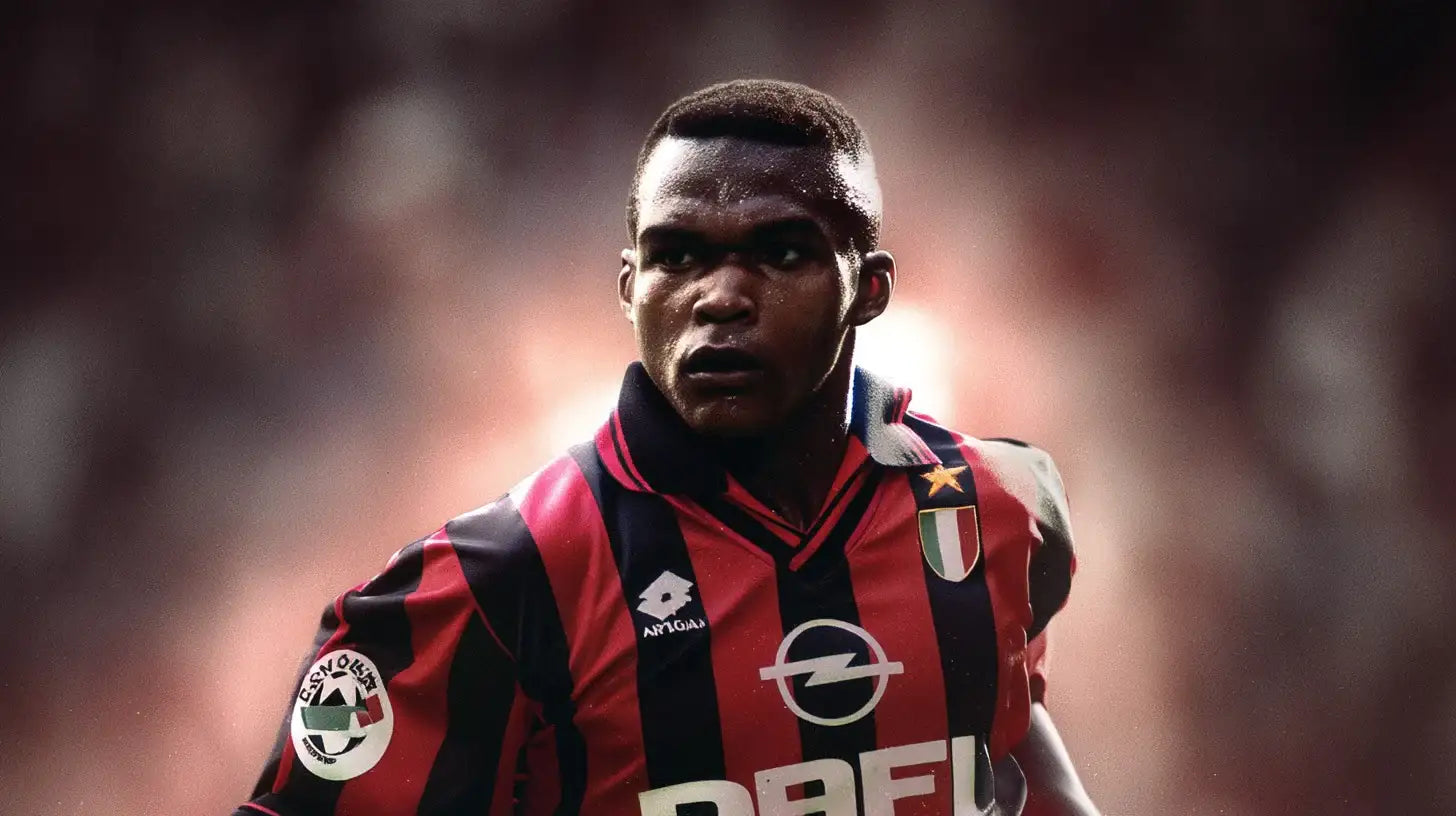 Marcel Desailly in black and red striped AC Milan football shirt with gold star and Scudetto badge on the chest.