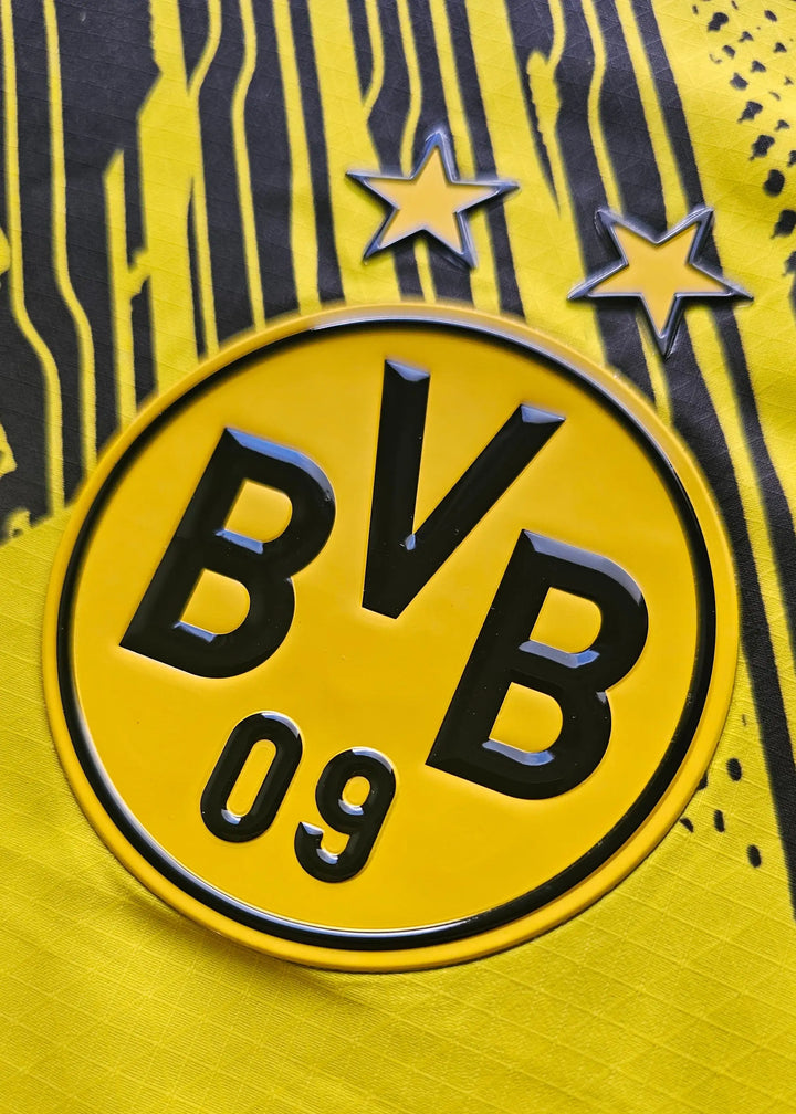 Detail of the Borussia Dortmund crest with two stars and 'BVB 09' text in black on yellow background.