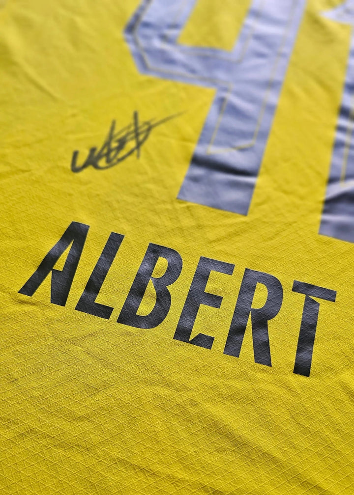 A signature by Mathis Albert sits below his grey No. 41 and above the ALBERT nameset on the yellow shirt back.