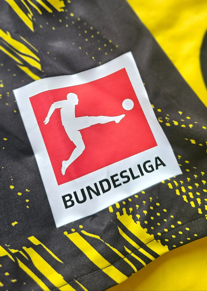 The red and white Bundesliga sleeve patch decorates the Borussia Dortmund shirt's black and yellow striped fabric.