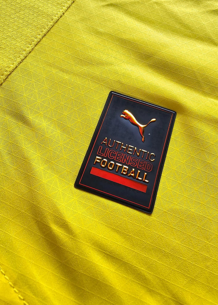 Close-up of the crest detail featuring the Puma logo with "AUTHENTIC LICENSED FOOTBALL" text.