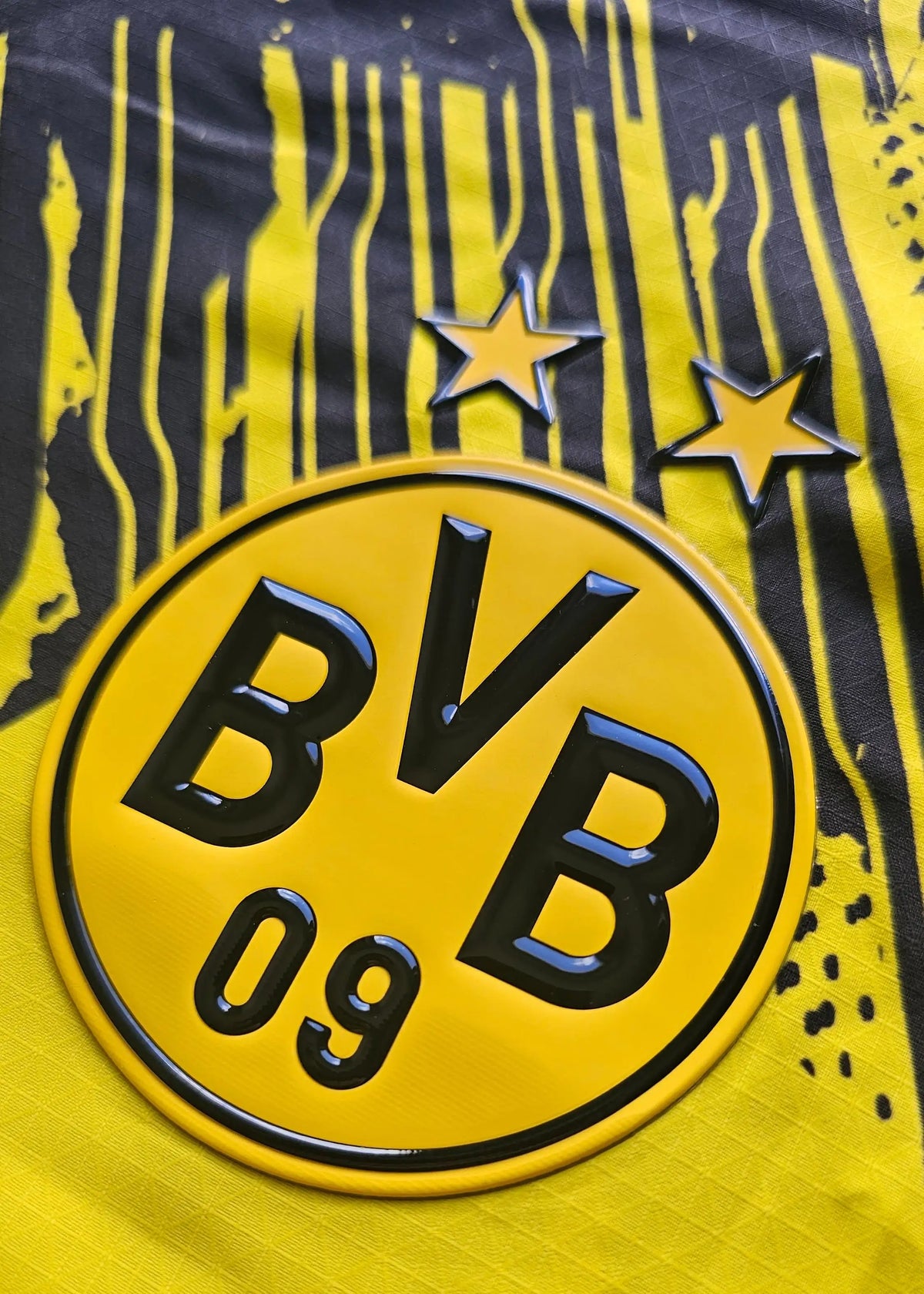 The BVB 09 crest and its two championship stars sit on the Borussia Dortmund shirt's striped yellow and black pattern.