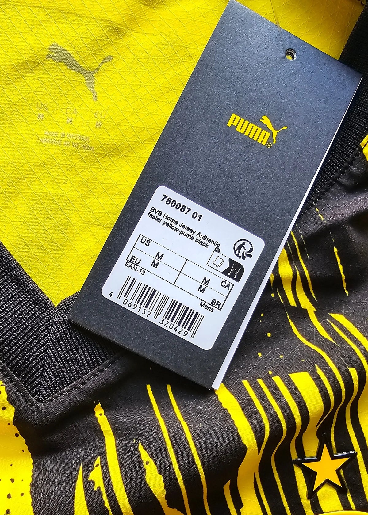 Yellow Borussia Dortmund shirt detail featuring the Puma logo and care tag.