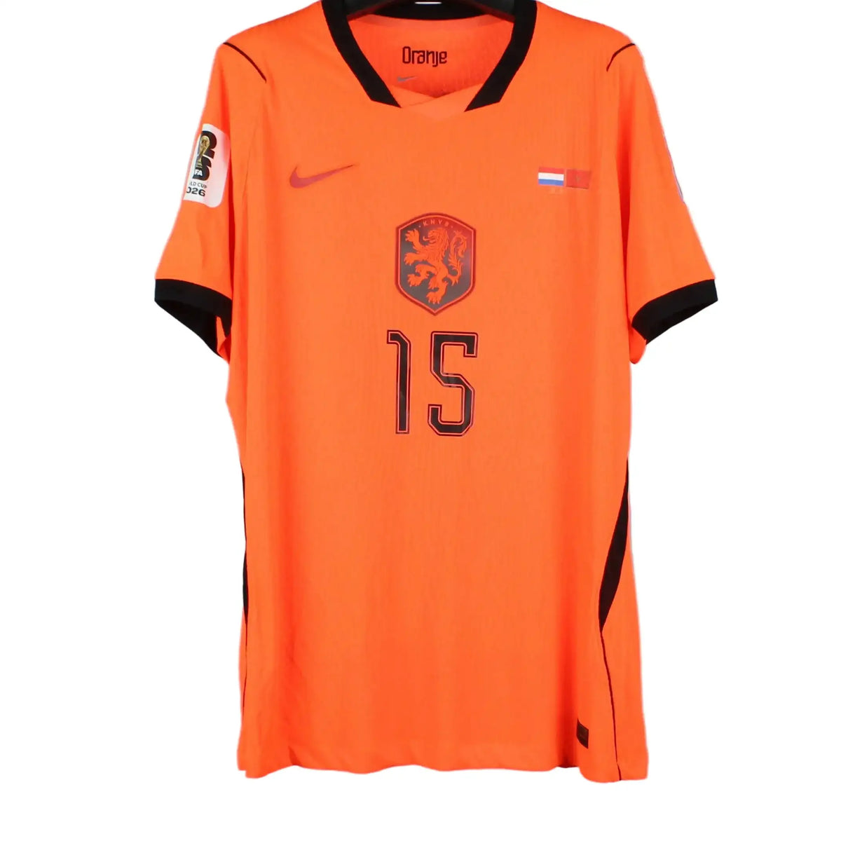 An orange Nike soccer jersey with black trim, featuring the number 15 and the Dutch national team crest, hanging on a black hanger against a gray background.
