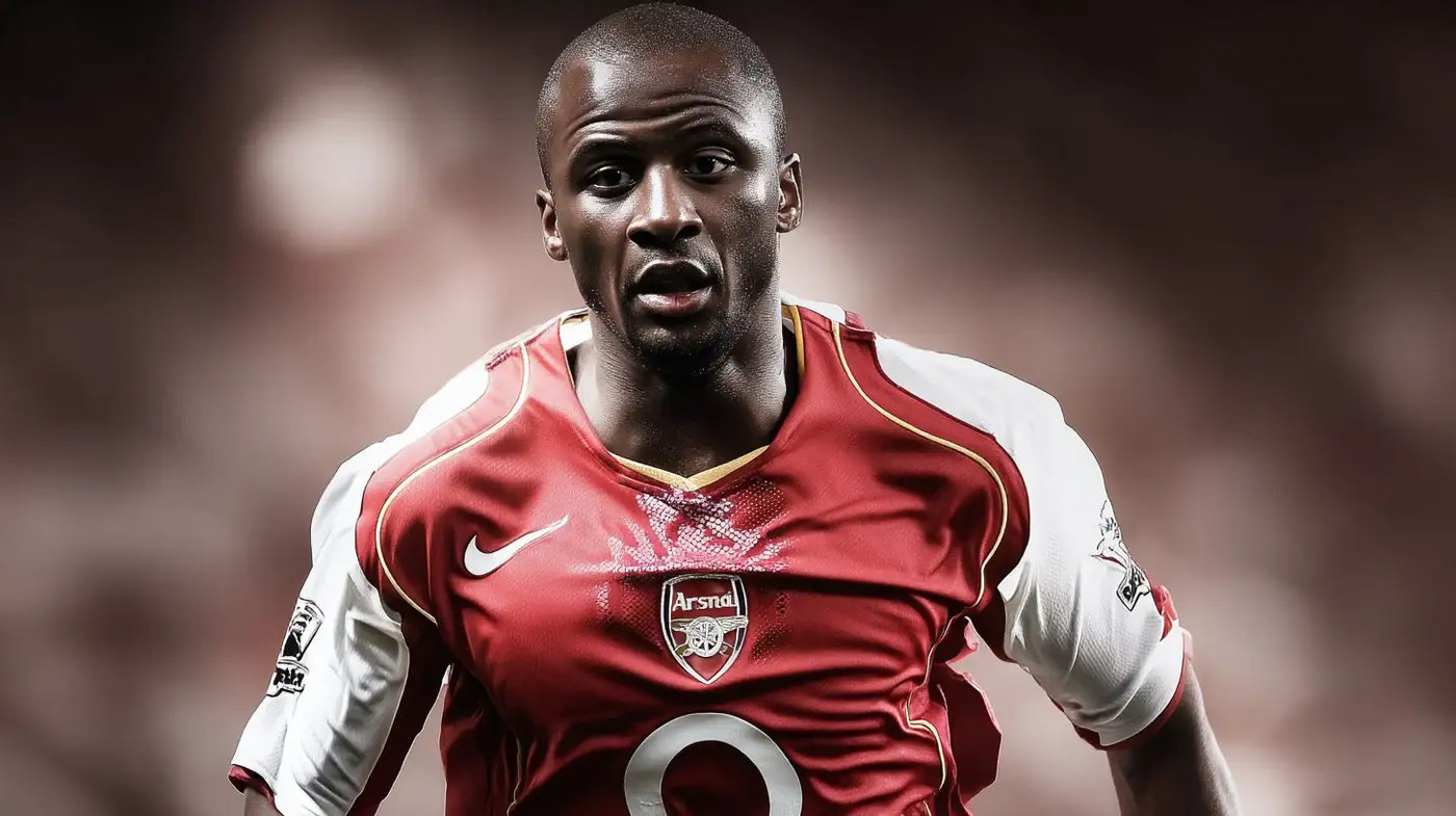 Patrick Vieira in classic Arsenal red and white kit running forward with determined expression.