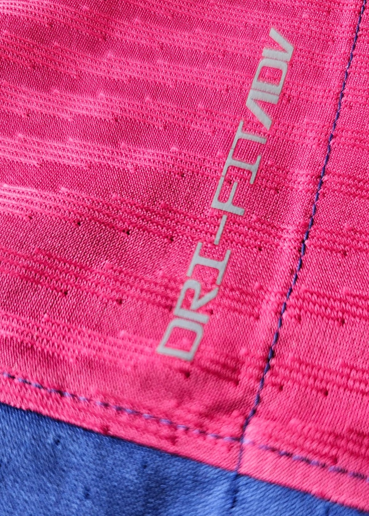 Grey Nike Dri-FIT ADV wordmark on a pink panel, stitched at the seam above a perforated blue section, on Pau Cubarsí's FC Barcelona 2025-2026 shirt.