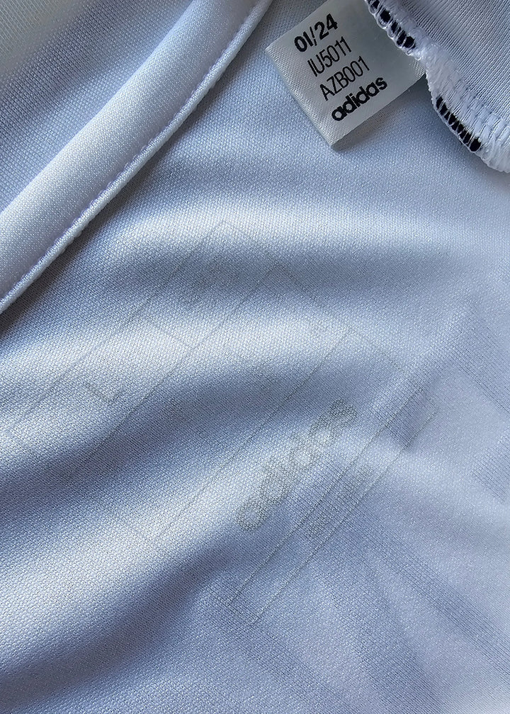 A close-up of the woven adidas production tag stitched into the seam of this Raul Asencio Real Madrid 2024-2025 shirt.