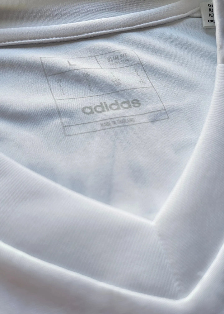 The inside collar label of this Raul Asencio Real Madrid 2024-2025 shirt shows size L, Slim Fit cut, and the adidas Made in Thailand tag.