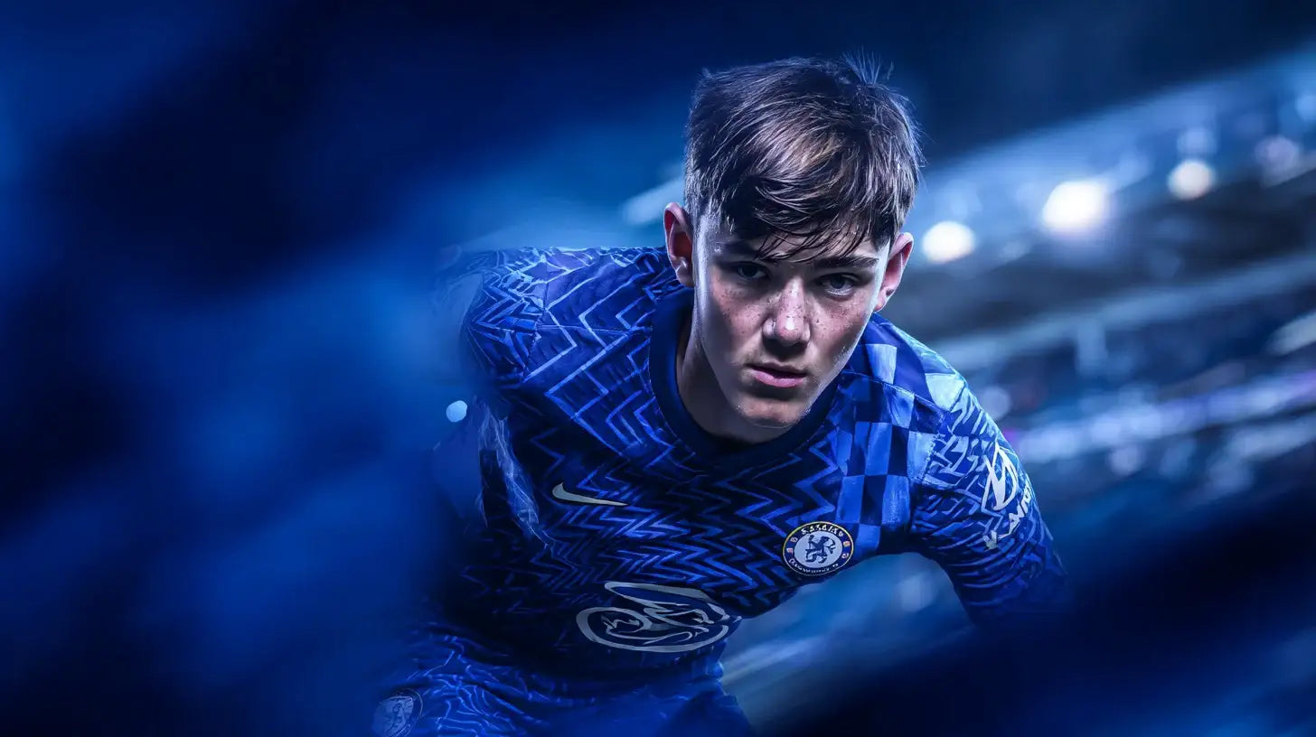 Reggie Walsh leans forward with a determined expression in a blue patterned Chelsea home football shirt, surrounded by deep blue motion blur inside the stadium.