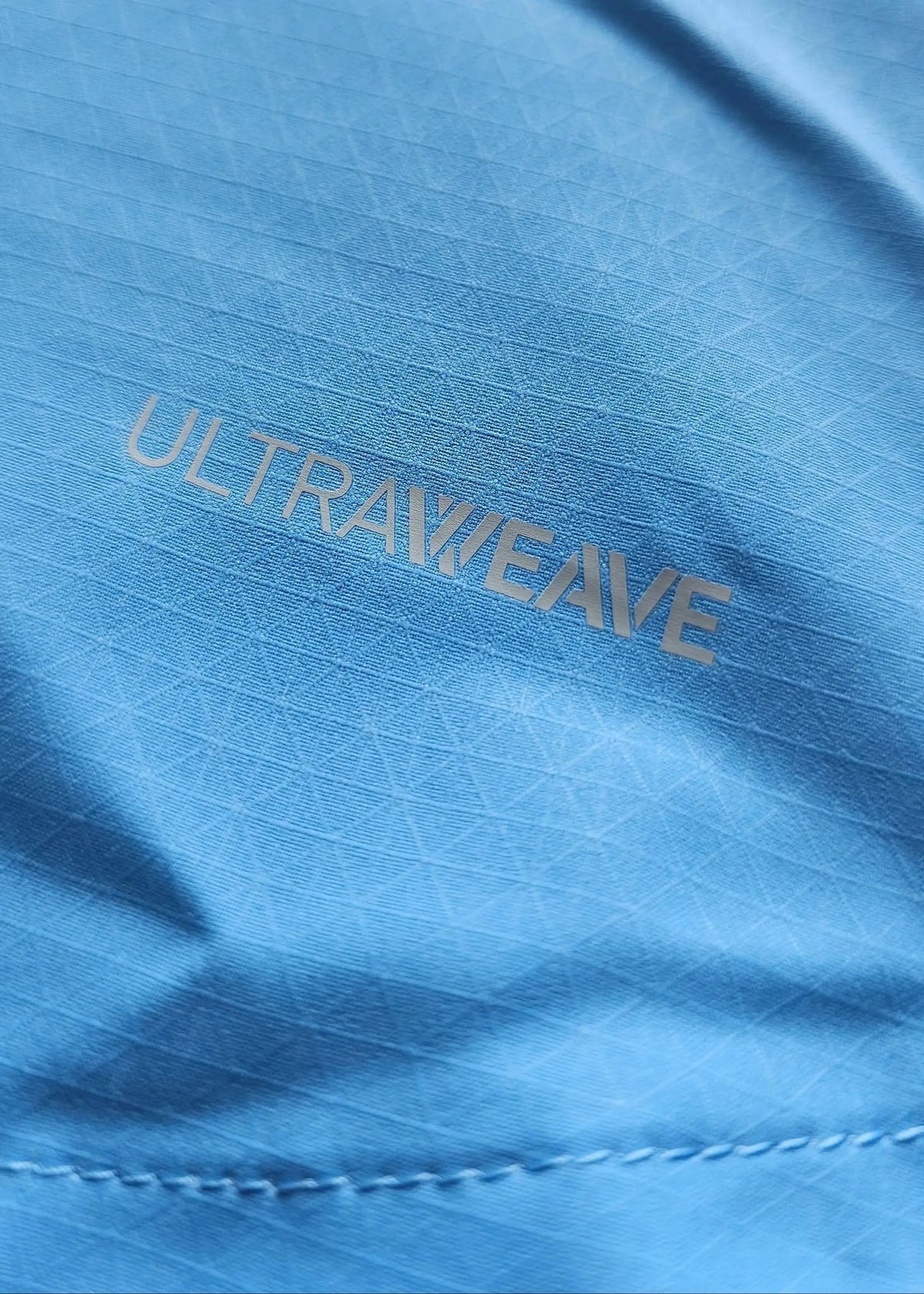 Close-up of the grey 'Ultraweave' fabric print on sky-blue ripstop material, from the signed Reigan Heskey Manchester City F.C. 2025-2026 shirt.