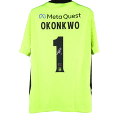 Back view showing No. 1, name Okonkwo, and signature detail on a neon green football shirt.