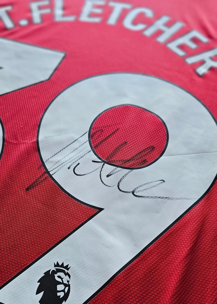 Close-up of the T.FLETCHER nameset and number, signed in black marker, on Tyler Fletcher's Manchester United F.C. Signed shirt.