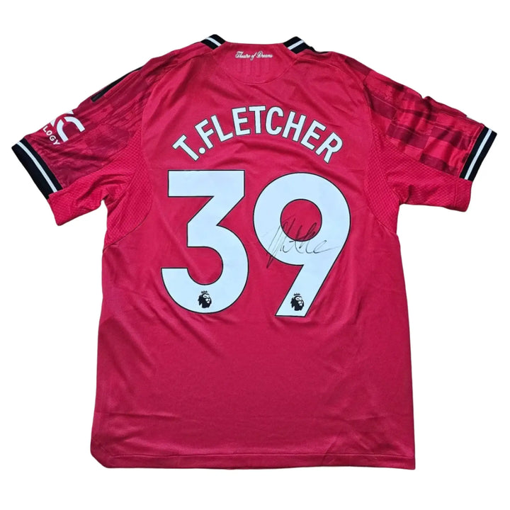 Back of a red shirt printed T.FLETCHER 39, signed in black marker across the 9, part of Tyler Fletcher's Manchester United F.C. Signed shirt.