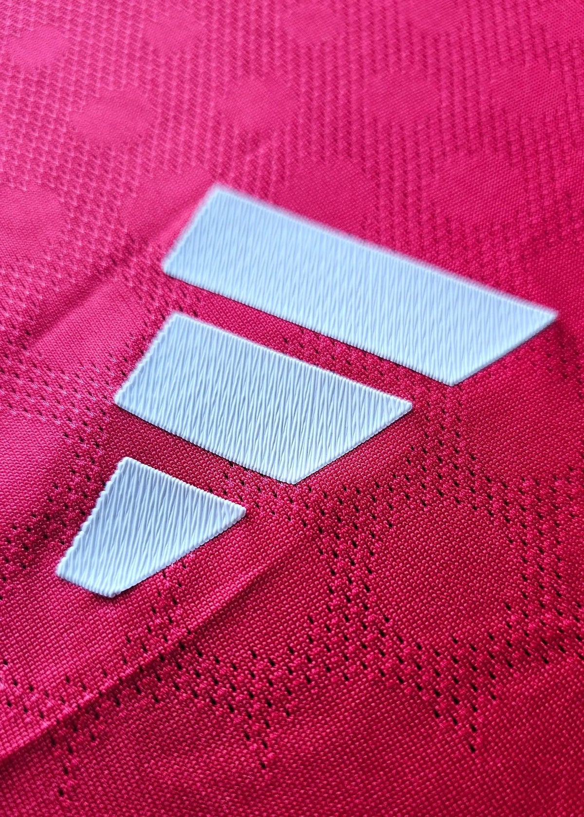 Close-up of the adidas three-stripe logo on the sleeve of Tyler Fletcher's Manchester United F.C. Signed shirt.