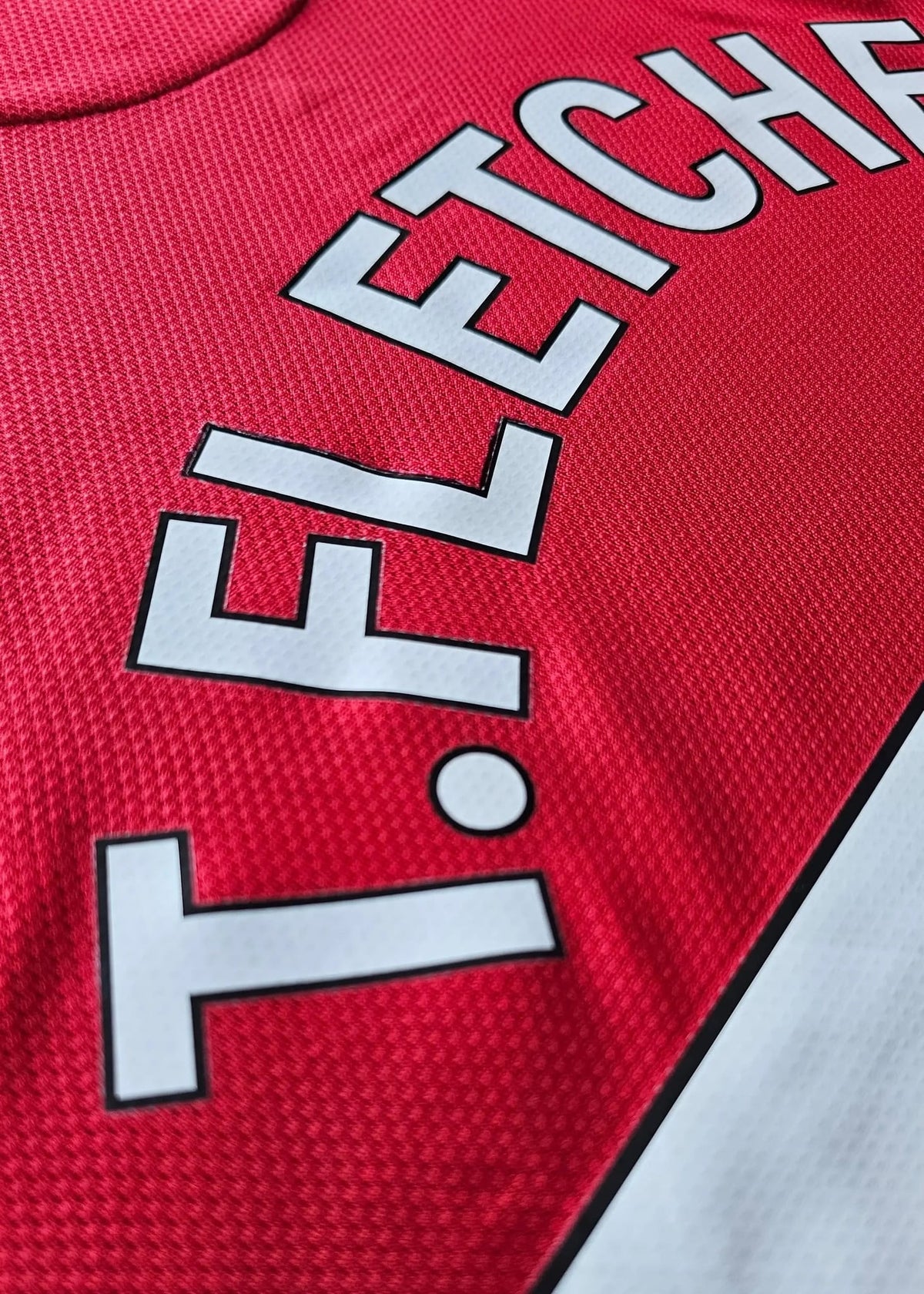 Close-up of the FLETCHER nameset lettering on the back of Tyler Fletcher's Manchester United F.C. Signed shirt.