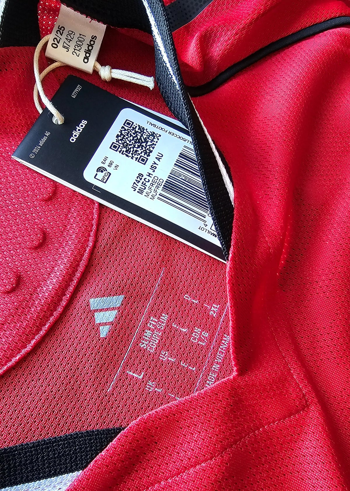 Interior view featuring adidas logo and care label; red fabric with black accents.