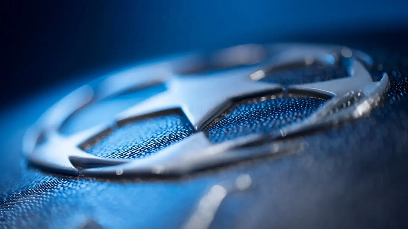 Macro view of silver starball logo on blue textured surface, symbolizing the UEFA Champions League.