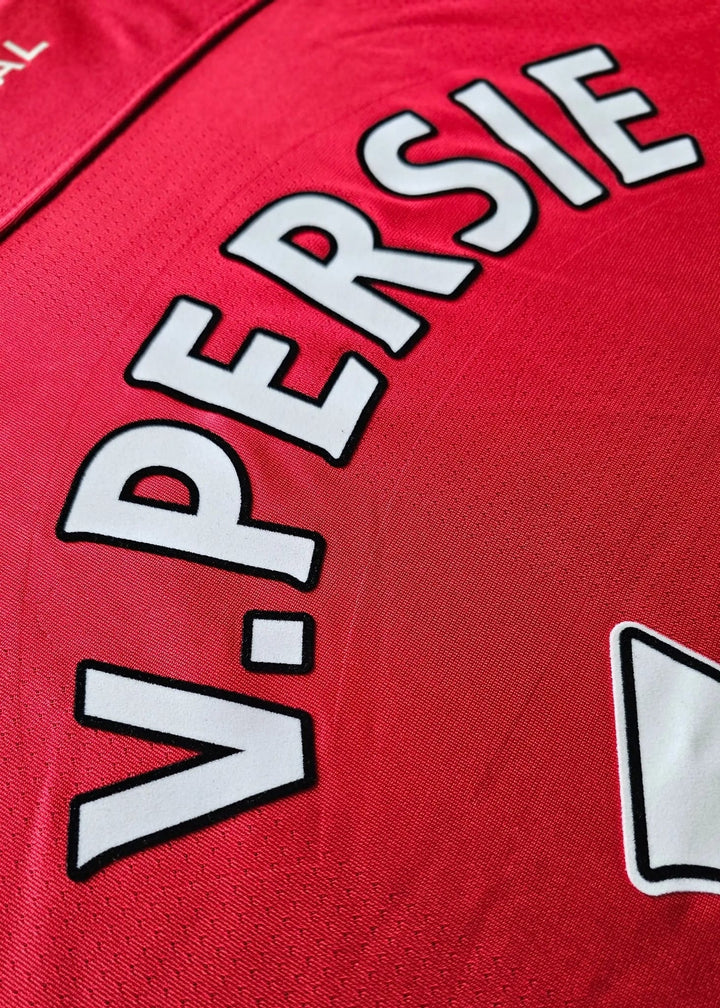 Close-up of a red sports jersey showing the back with the name 'V. PERSIE' in white letters with black outlines, and part of a white crest.