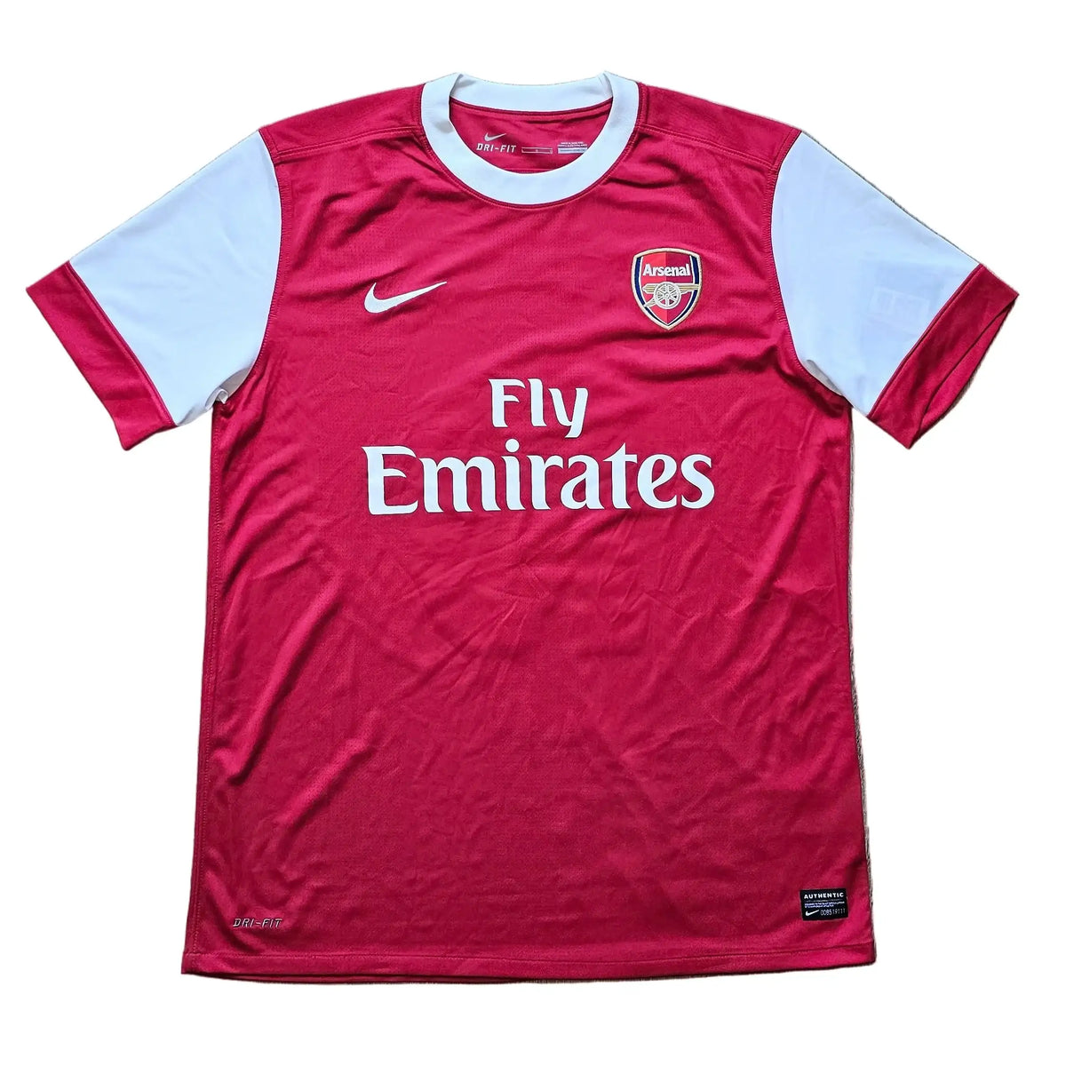 Arsenal home shirt laid flat with Nike swoosh, club crest and Fly Emirates on the chest, Robin van Persie's signed 2010-11 No. 10 shirt.