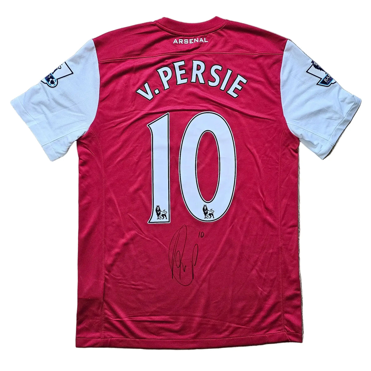 Back of a red and white Arsenal 2011-12 shirt with the V.PERSIE nameplate, number 10 flanked by Premier League lion badges, and a black signature below.