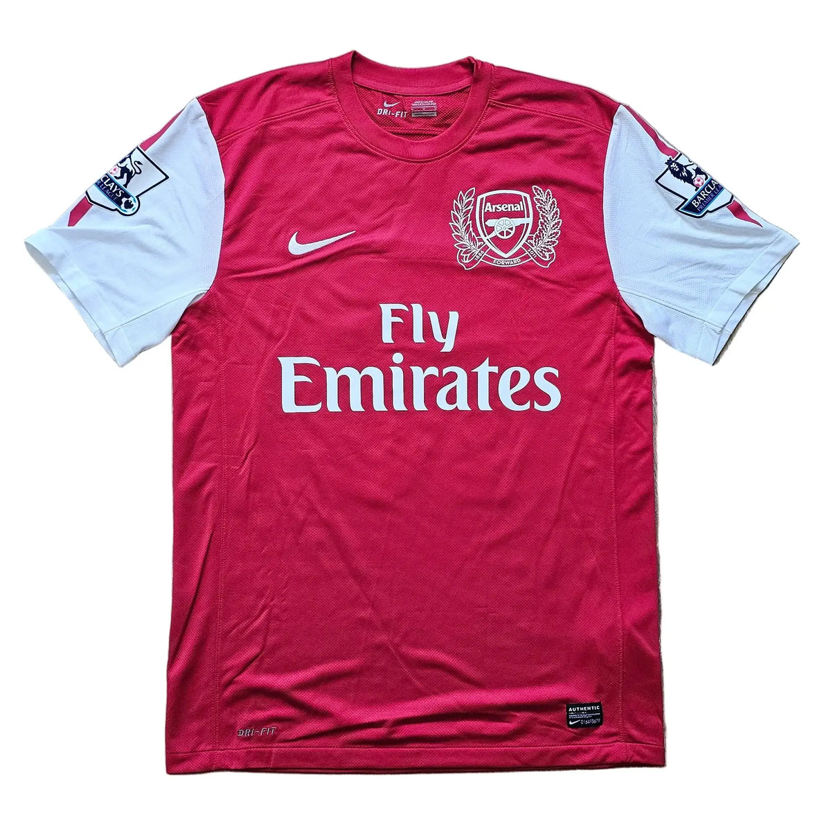 Front of a red and white Arsenal 2011-12 home shirt with the Nike swoosh, Arsenal crest, and Fly Emirates sponsor across the chest, No. 10.